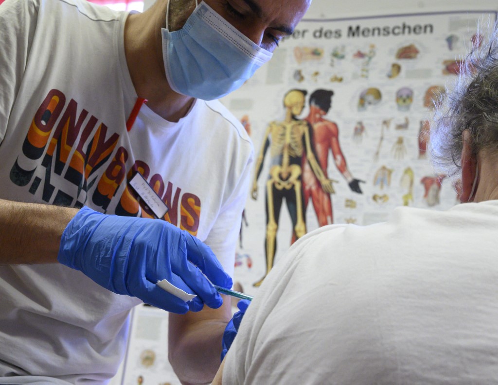 Un homme reçoit un vaccin contre le coronavirus BioNtech-Pfizer Covid-19 dans un centre de vaccination mobile à Hemmingen près de Ludwigsburg, dans le sud de l'Allemagne, le 7 décembre 2021. (AFP)