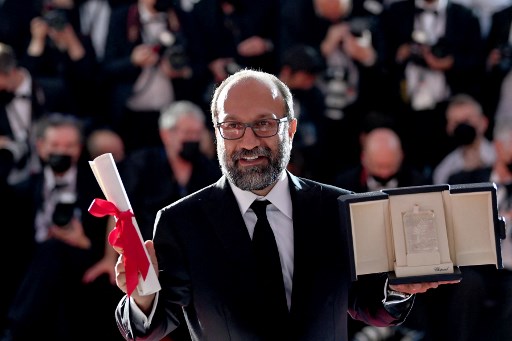 Cette photo d'archive prise le 17 juillet 2021 montre le réalisateur iranien Asghar Farhadi posant avec son trophée après avoir également reçu le Grand Prix pour son film "Ghahreman"(A Hero)" lors de la cérémonie de clôture de la 74e édition de au Festival de Cannes. "Ghahreman" (Un Héros) sort dans les salles françaises le 15 décembre 2021.(Christophe Simon/AFP)