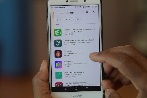 Un homme montre sur son smartphone les différents types de services de prêt mobile affichés sur son écran, le 9 décembre, à Nairobi. (Simon Maina / AFP)