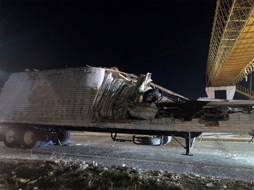 Des travailleurs retirent le conteneur de la remorque d'un camion qui s'est écrasé avec des migrants à bord lors d'un accident de la route à Tuxtla Gutierrez. Au moins 53 migrants ont été tués le 9 décembre au Mexique quand le camion dans lequel ils étaient cachés a heurté un mur de soutènement et s'est renversé dans l'État du Chiapas, au Mexique, le 9 décembre 2021. (Gabriela Coutino/AFP )