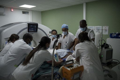 Des membres du personnel médical préparent un patient Covid-19 sous assistance respiratoire à un examen médical à l'hôpital André-Grégoire de Montreuil, à l'est de Paris, le 14 décembre 2021. (Julien De Rosa/AFP)