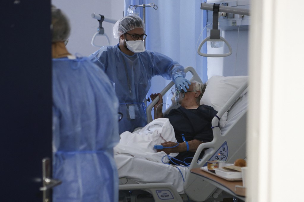 Des agents de santé prennent en charge une patiente âgée dans une unité dédiée aux patients infectés par le Covid-19 à l'hôpital de Bastia, en Corse, le 15 décembre 2021. (Photo,AFP)