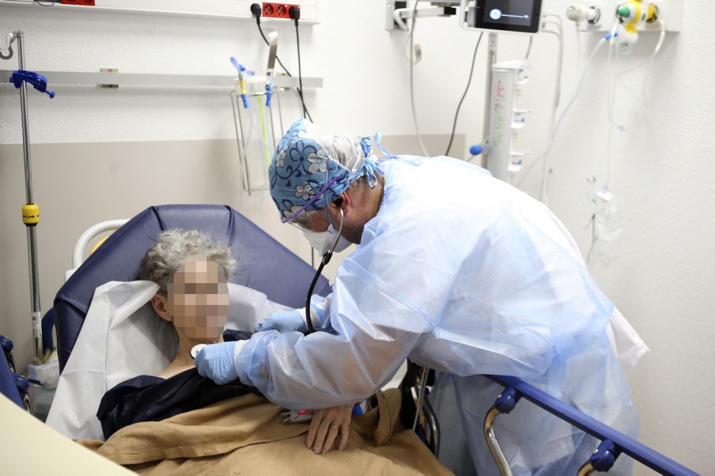 Un agent de santé en charge du service des urgences Covid avec une patiente âgée infectée par le Covid-19 à l'hôpital de Bastia en Corse, le 15 décembre 2021.(AFP)