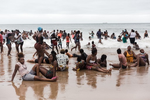 Baigneurs dans l'océan le long du front de mer du Golden Mile de Durban à Durban le 16 décembre 2021, au milieu de l'augmentation quotidienne des cas de Covid-19.(Rajesh Jantilal/AFP)