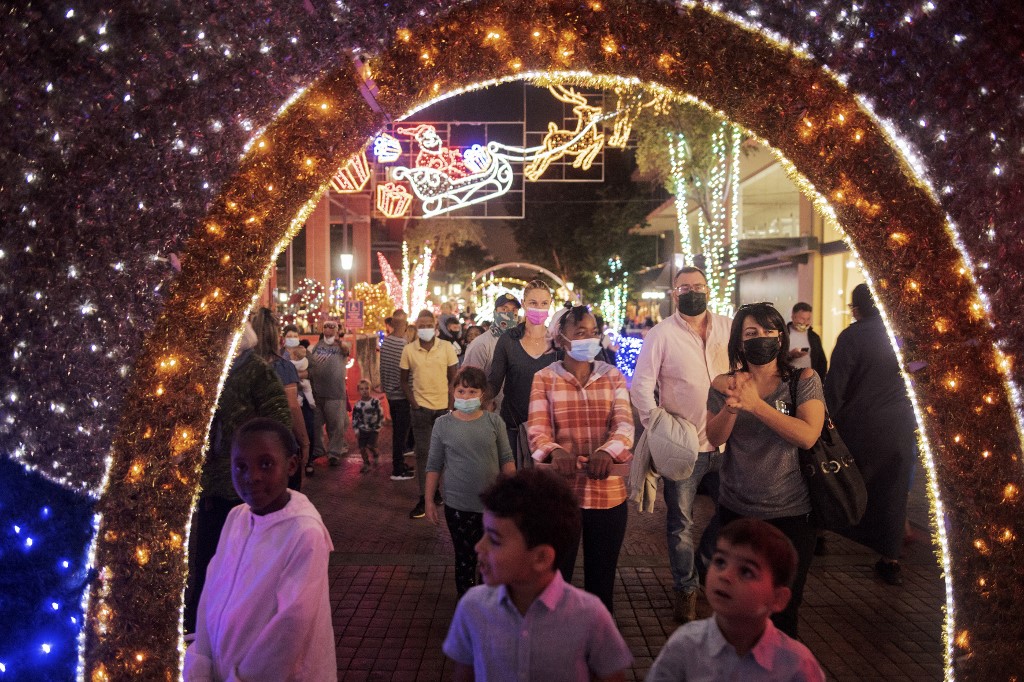 Des personnes apprécient les décorations de Noël à Melrose Arch, à Johannesburg, le 21 décembre 2021. (AFP)