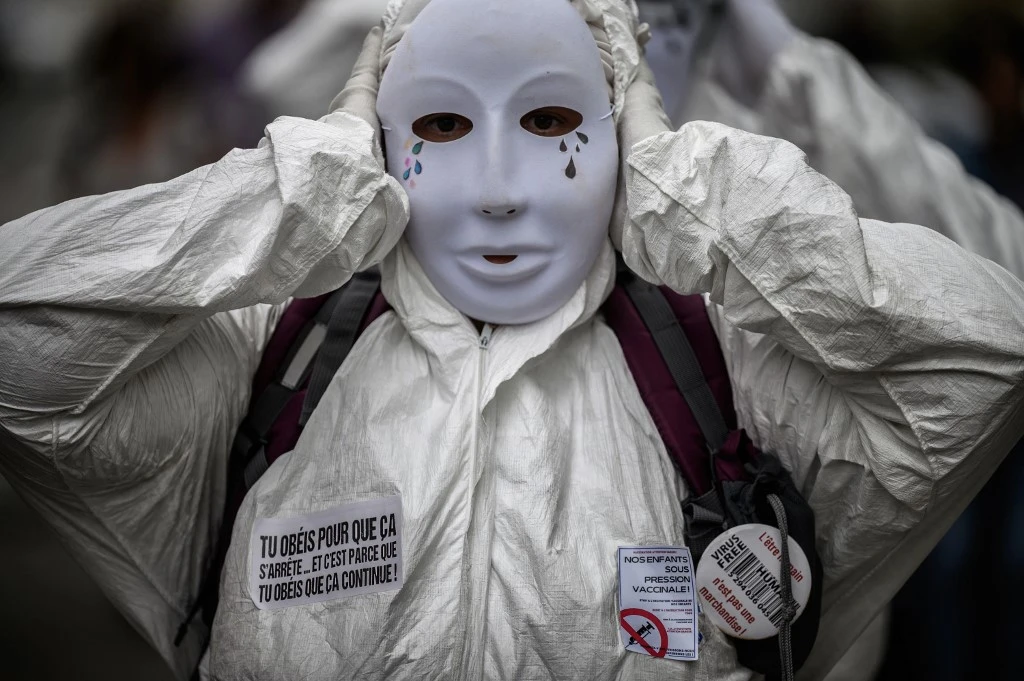Un manifestant porte un masque et un équipement de protection individuelle lors de la manifestation devant l'ARS (agence régionale de la santé) à Lyon, dans le sud-est de la France, le 14 septembre 2021, contre l'obligation du pass sanitaire obligatoire. (AFP)
