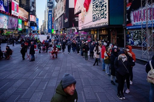 Les gens font la queue à un stand de test Covid-19 côté rue à Times Square à New York le 20 décembre 2021. Le 18 décembre, l'État de New York a annoncé un nombre record de cas quotidiens pour la deuxième journée consécutive avec près de 22 000 résultats positifs. (Ed Jones/AFP)