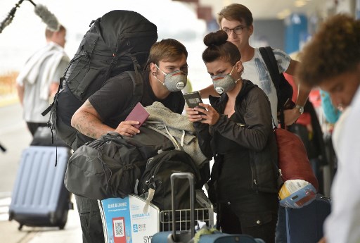 Des ressortissants français font la queue devant l'aéroport international de Sydney pour être rapatriés en France le 2 avril 2020, au milieu de la pandémie de coronavirus COVID-19. (Peter Parcs/AFP)