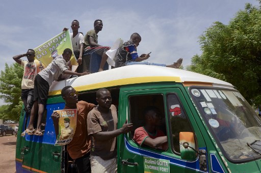 Des partisans célèbrent l'arrivée du nouveau président du gouvernement de transition du Mali, Assimi Goita, à son retour d'Accra après une réunion avec les représentants de la CEDEAO (Communauté économique des États de l'Afrique de l'Ouest) le 31 mai 2021. (Michèle Cattani/AFP)