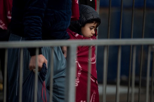 Un jeune migrant est aidé à terre, après avoir été récupéré en mer alors qu'il tentait de traverser la Manche, à la marina de Douvres, dans le sud-est de l'Angleterre, le 4 janvier 2022. (Ben Stansall / AFP)