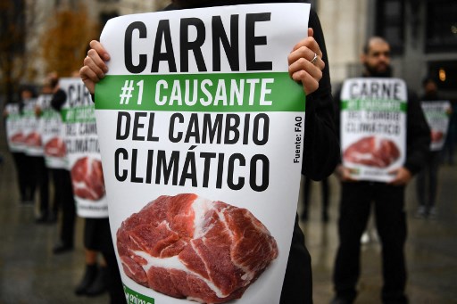 Dans cette photo d'archives prise le 1er décembre 2019, des militants tiennent des pancartes indiquant «la viande est la première cause du changement climatique», alors qu'ils participent à une manifestation organisée par l'organisation internationale de défense des animaux à but non lucratif AnimaNaturalis, à Madrid. (Gabriel Bouys/AFP)