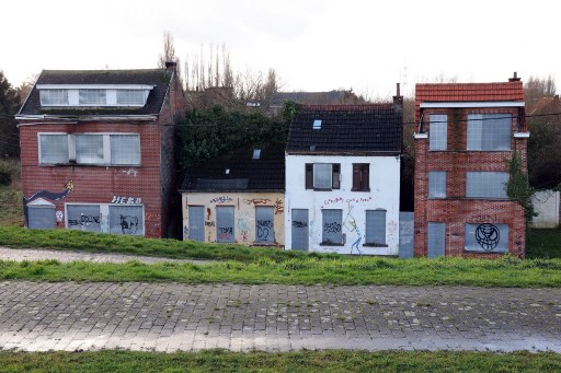 Cette photographie prise le 7 janvier 2022 montre des maisons abandonnées à Doel près de la ville d'Anvers. Le village de Doel fait face à sa bataille finale pour sa survie contre les plans d'expansion du port adjacent d'Anvers qui l'effaceront de la carte pour faire place à un nouveau quai à Doel près de la ville portuaire d'Anvers. (François Walschaerts/AFP)