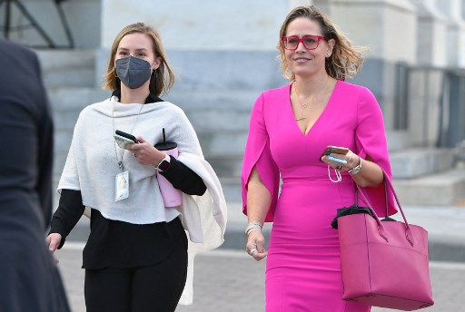 Dans cette photo d'archive prise le 28 octobre 2021, le sénateur Kyrsten Sinema (à droite), quitte le Capitole à Washington, DC. (Mandel Ngan/AFP)