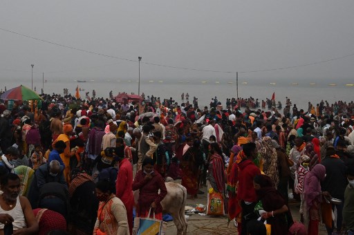 Des pèlerins hindous accomplissent des rituels après avoir pris un bain sacré au confluent du Gange et de la baie du Bengale pendant le Gangasagar Mela à l'occasion de Makar Sankranti, un jour considéré comme d'une grande importance religieuse dans la mythologie hindoue, sur l'île de Sagar, à environ 150 km au sud de Calcutta le 14 janvier 2022. (Dibyangshu Sarkar / AFP)