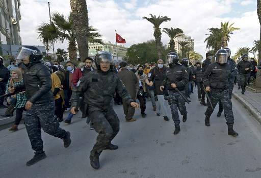 La police tunisienne avance sur les manifestants lors des manifestations contre le président Kais Saied, à l'occasion du 11e anniversaire de la révolution tunisienne dans la capitale Tunis le 14 janvier 2022. (Fethi Belaid / AFP)