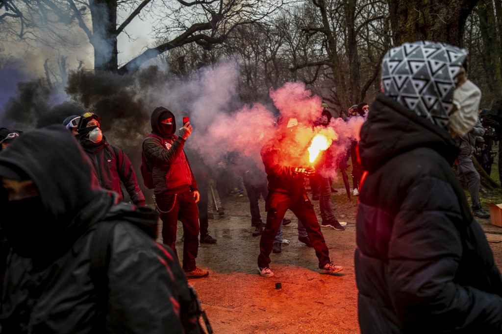 Des manifestants filment et brandissent des fumigènes lors d'une manifestation pour "la liberté, la démocratie et les droits de l'homme" organisée par l'alliance Européens unis à Bruxelles, le 23 janvier 2022.(AFP)