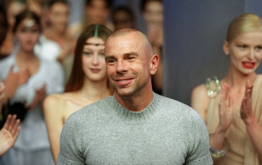 Dans cette photo d'archive prise le 3 octobre 1999, le couturier français Thierry Mugler est acclamé par ses mannequins et le public après la présentation de sa collection de prêt-à-porter printemps-été 2000 à Paris. (Thomas Coex/AFP)