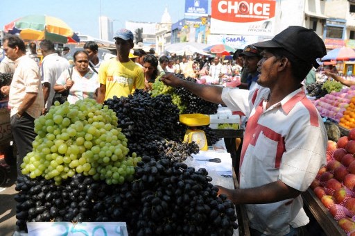 Un vendeur de rue sri-lankais vend des fruits sur un trottoir à Colombo le 15 mars 2010. Le colportage est illégal, mais de nombreux trottoirs sont bloqués par les vendeurs. (Lakruwan Wanniarachchi/AFP)