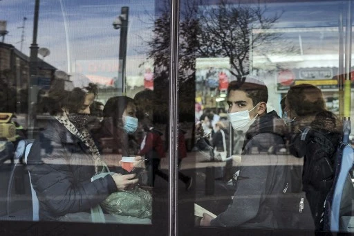 Passagers portant un masque sanitaire dans un bus en Israël (AFP)