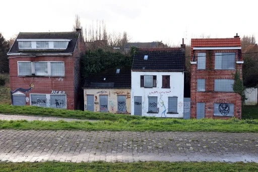 Cette photographie prise le 7 janvier 2022 montre des maisons abandonnées à Doel près de la ville d'Anvers. Le village de Doel fait face à sa bataille finale pour sa survie contre les plans d'expansion du port adjacent d'Anvers qui l'effaceront de la carte pour faire place à un nouveau quai à Doel près de la ville portuaire d'Anvers. (François Walschaerts/AFP)