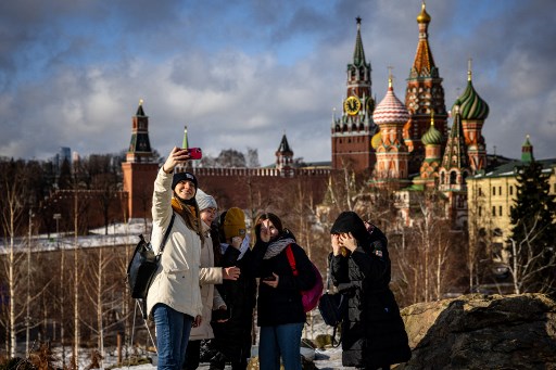Des femmes prennent une selfie au parc Zaryadye devant le Kremlin et la cathédrale Saint-Basile dans le centre de Moscou le 22 février 2022. Le président russe Vladimir Poutine a déclaré le 22 février qu'il ne prévoyait pas de restaurer l'empire russe, un jour après qu'il a ordonné l'envoi de troupes russes dans l'est de l'Ukraine et a remis en question la souveraineté de l'Ukraine. (Dimitar Dolkoff/AFP)