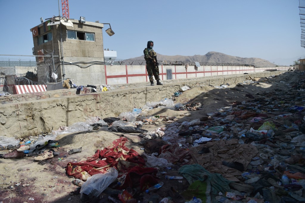 Un taliban monte la garde sur le site des deux attentats-suicides du 26 août, qui ont tué des dizaines de personnes, dont 13 soldats américains, à l'aéroport de Kaboul le 27 août 2021. (AFP)