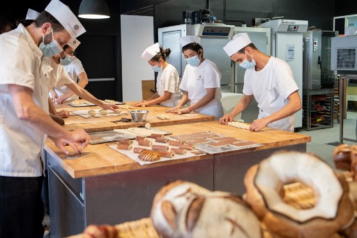 Des stagiaires suivent un programme de formation culinaire intitulé «Comment cuisiner» dans une école culinaire à Paris le 12 novembre 2021. (Bertrand Guay/AFP)