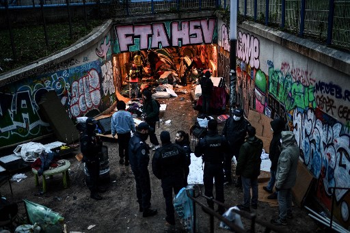 La police sécurise la zone lors d'une opération d'évacuation d'un camp de migrants de fortune installé sous un tunnel piétonnier passant sous le périphérique entre Paris et la banlieue nord-est du Pré Saint Gervais tôt le 10 décembre 2021. (Christophe Archambault/AFP)