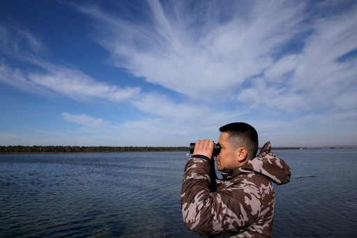 Un garde forestier surveille les oiseaux dans le lagon de Karavasta, dans le parc national de Divjaka-Karavasta, en Albanie, le 31 janvier 2022. (Gent Shkullaku/AFP)