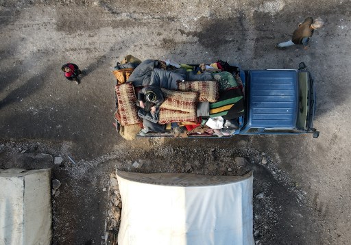 Des Syriens déplacés internes chargent leurs affaires sur un camion dans un camp, avant d'être transportés vers un nouveau complexe de logements tenu par l'opposition dans le nord du gouvernorat d'Alep, construit avec le soutien de l'agence d'urgence turque AFAD, le 9 février 2022. (Bakr Alakasem/AFP)