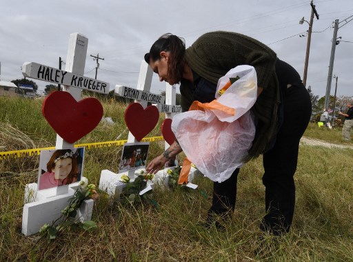 Jessica Mires dépose des fleurs sur des croix portant le nom des victimes à l'extérieur de la première église baptiste, qui a été le théâtre de la fusillade de masse qui a fait 26 victimes à Sutherland Springs, Texas, le 9 novembre 2017. (Marque Ralston/AFP)