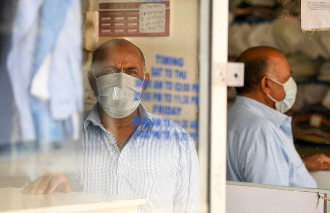Un homme portant un masque à l’intérieur d’un pressing à Dubaï, aux Émirats arabes unis. (AFP