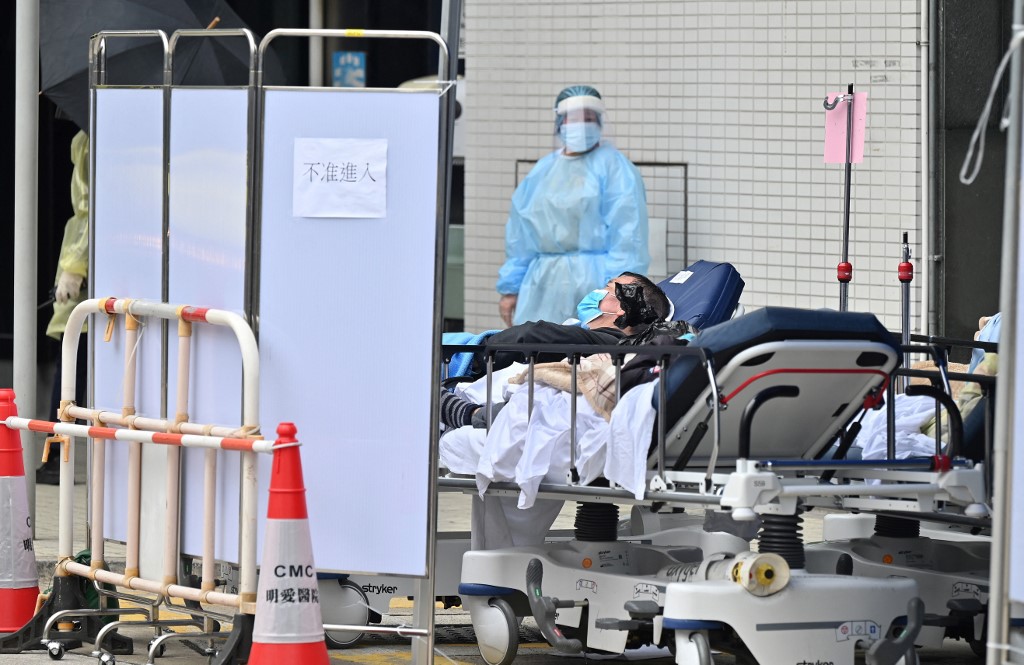 Des personnes sont allongées sur des lits d'hôpital devant le centre médical Caritas à Hong Kong. (AFP).