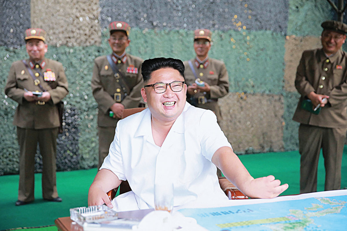 Le dirigeant nord-coréen Kim Jong-un (au centre) passe en revue un exercice de lancement de missiles balistiques par l'Armée populaire de Corée, le 21 juillet 2016. (KCNA via KNS/AFP)