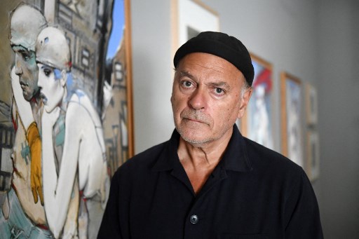 L'auteur, artiste et réalisateur de bandes dessinées français Enki Bilal pose à côté de ses œuvres lors de son exposition au « Fonds Helene et Edouard Leclerc « à Landerneau, dans l'ouest de la France, le 17 juillet 2020. (Fred Tanneau/AFP)