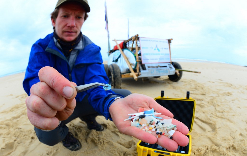 Le scientifique français et membre de l'association "4P Shore & Seas" Edgar Dusacre montre des déchets microplastiques collectés sur la côte aquitaine sur la plage de Contis, dans le sud-ouest de la France, le 17 août 2020. (AFP).