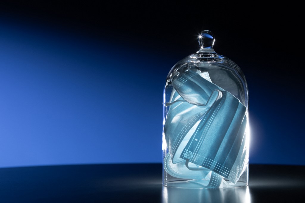 Des masques de protection sont photographiés sous une cloche de verre, à Paris. (AFP).