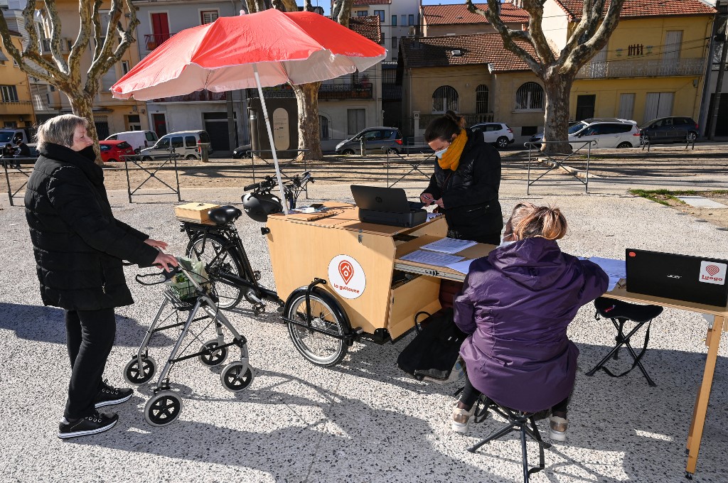 Un travailleur social aide les habitants du quartier à résoudre des problèmes administratifs en ligne à Béziers, France. (AFP).