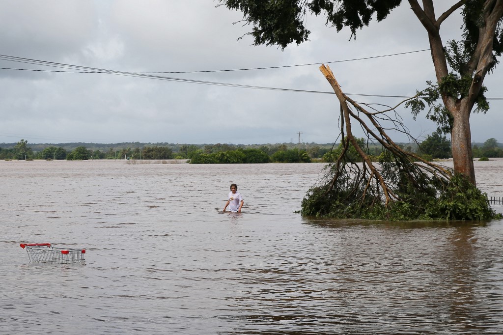 Une fille traversant les eaux de crue de la rivière Hawkesbury dans la banlieue de Sydney, en Australie. (AFP).