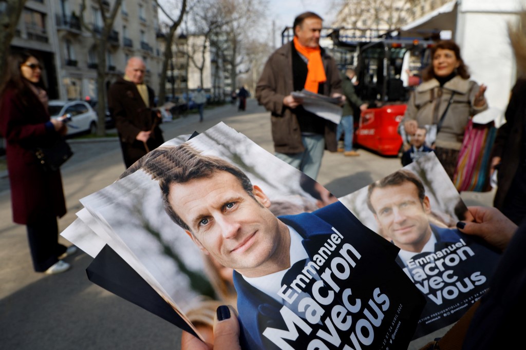 Les bénévoles du parti centriste français La République en marche (LREM) distribuent des dépliants de campagne du président français et candidat à sa réélection Emmanuel Macron sur un marché à Paris le 5 mars 2022. (AFP)