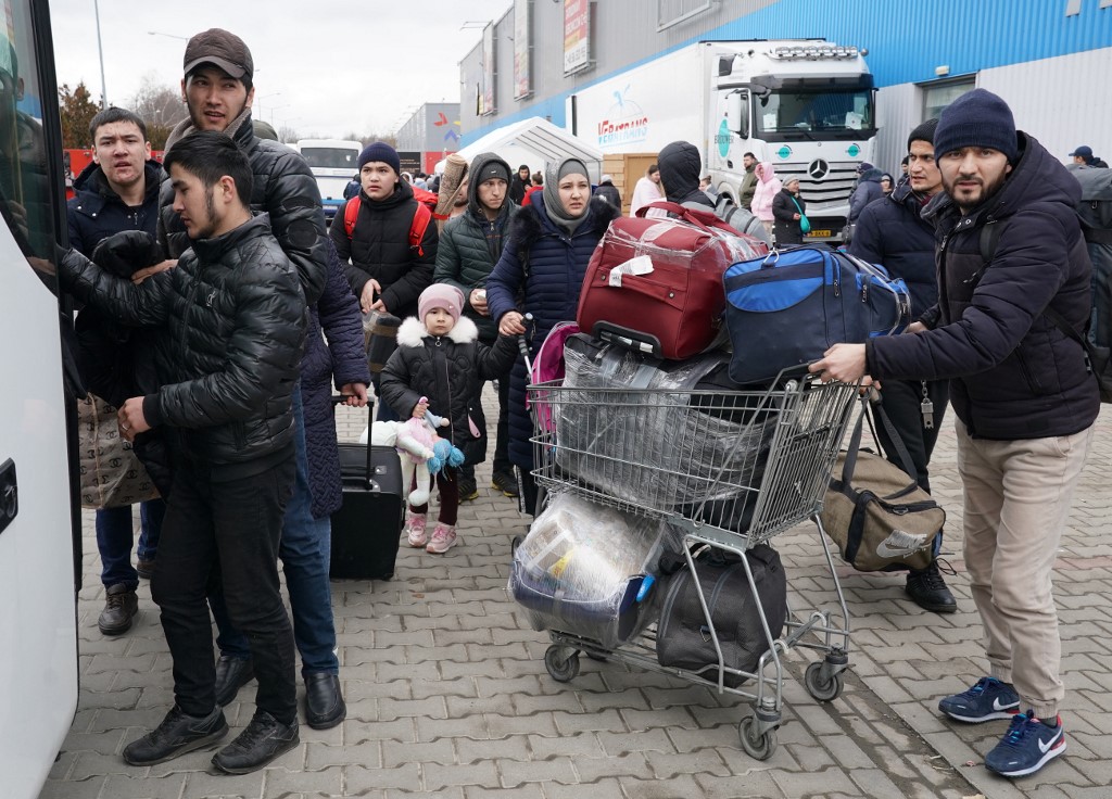 Des réfugiés d'Ukraine faisant la queue pour un bus vers d'autres destinations au centre de distribution de Korczowa, en Pologne. (AFP).