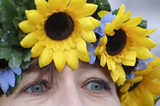Une manifestante porte des fleurs bleues et jaunes lors d'un rassemblement de soutien à l'Ukraine à Los Angeles, Californie, le 5 mars 2022. (Ringo Chiu/AFP)