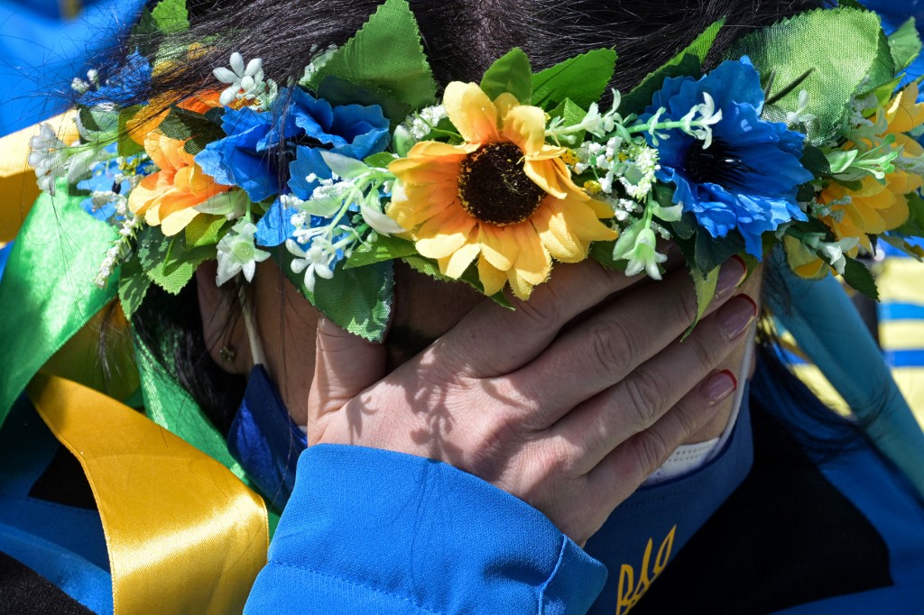 Une membre de l'équipe ukrainienne pleure pendant une minute de silence au village des athlètes de Zhangjiakou lors des Jeux paralympiques d'hiver de Pékin 2022, le 10 mars 2022. (AFP).