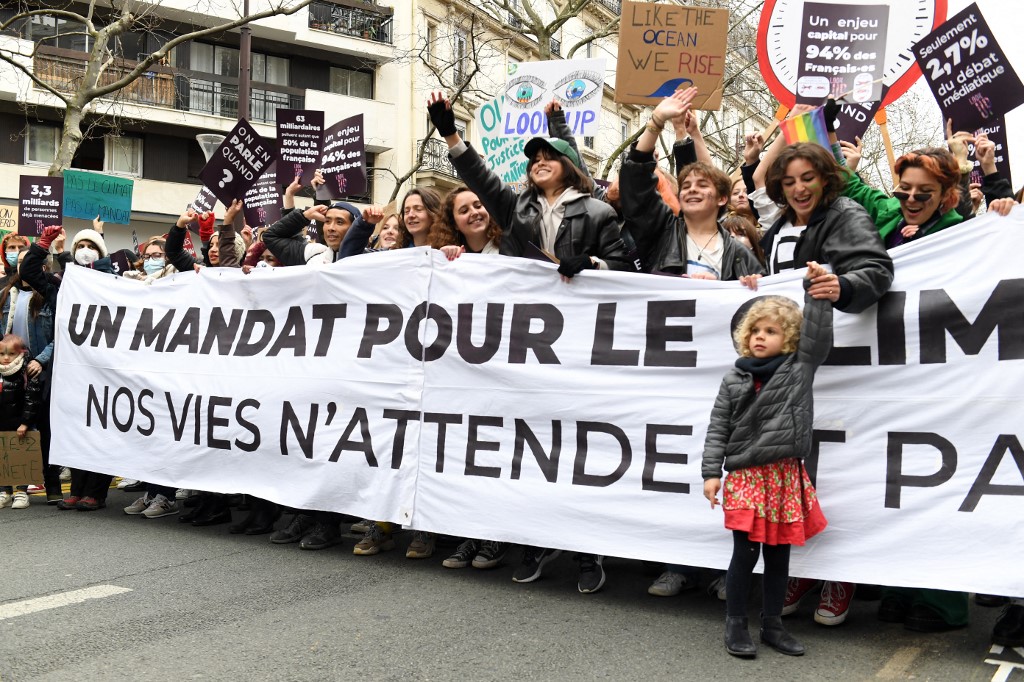 Des manifestants tiennent une banderole lors d'une marche "Look up", pour appeler les candidats à la présidentielle française à prendre en compte l'urgence climatique. (AFP).