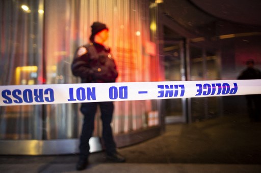 Sur cette photo d'archive prise le 12 mars 2022, un policier de la ville de New York se tient derrière un cordon de police à l'entrée du Museum of Modern Art de New York. La police de New York a appelé le public à aider à identifier un homme qui a tiré sur deux sans-abri le 12 mars, tuant l'un d'eux alors qu'il dormait dans la rue. (Kéna Betancur / AFP)