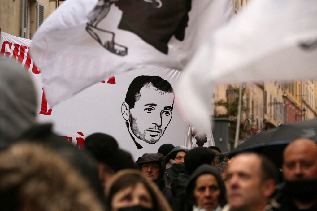 Des manifestants brandissent une banderole représentant Yvan Colonna à Bastia le 13 mars 2022, lors d'un rassemblement de soutien à la figure nationaliste corse, une semaine après son agression en prison à Arles. (AFP)