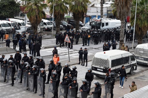 Les forces de sécurité tunisiennes montent la garde lors d'une manifestation contre le président du pays, non loin du siège de l'Assemblée tunisienne, dans la capitale Tunis, le 20 mars 2022. (Fethi Belaid/AFP)