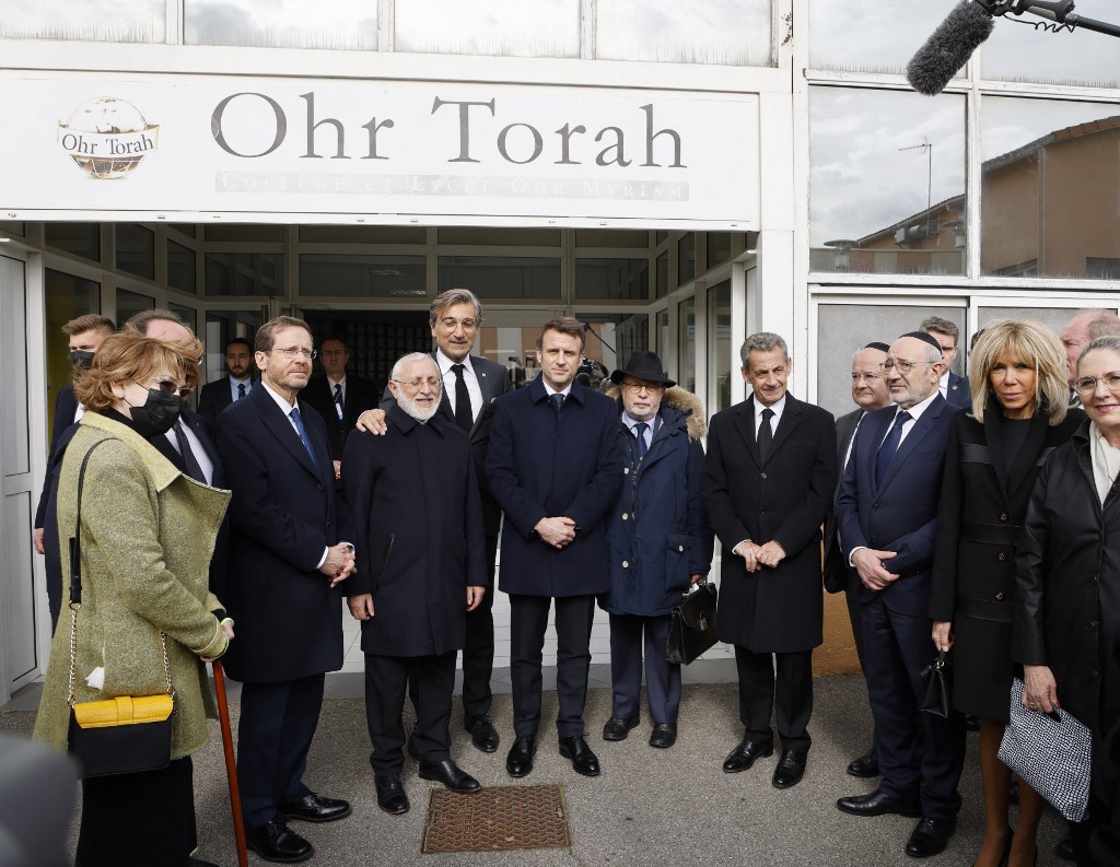 Le président français Emmanuel Macron et le président israélien Isaac Herzog (2e à gauche), avec Yaacov Monsonego (3e à gauche), directeur de l'école et père de Myriam tuée par Merah, et d'autres personnalités devant l'entrée du collège et du lycée Ohr Torah à Toulouse. (AFP).