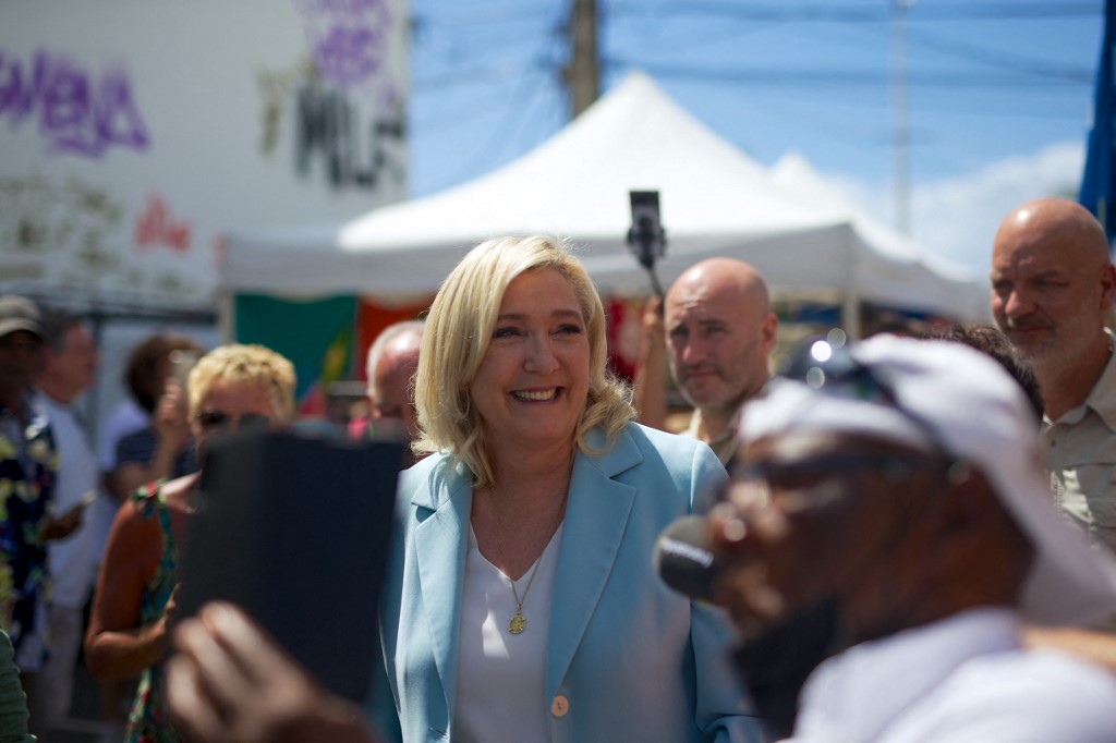 Marine Le Pen (C), candidate à la présidence du parti d'extrême droite français RN, visite un marché dans le cadre de son voyage de campagne dans l'île des Caraïbes françaises de la Guadeloupe, le 27 mars 2022 à Saint-Anne. (AFP)