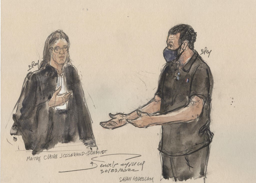 Ce croquis d'audience réalisé le 30 mars 2022 montre l'avocate française Claire Josserand-Schmidt, représentant la partie civile, (G) écoutant son coaccusé Salah Abdeslam, le principal suspect des attentats, lors du procès du 13 novembre 2015. (AFP).